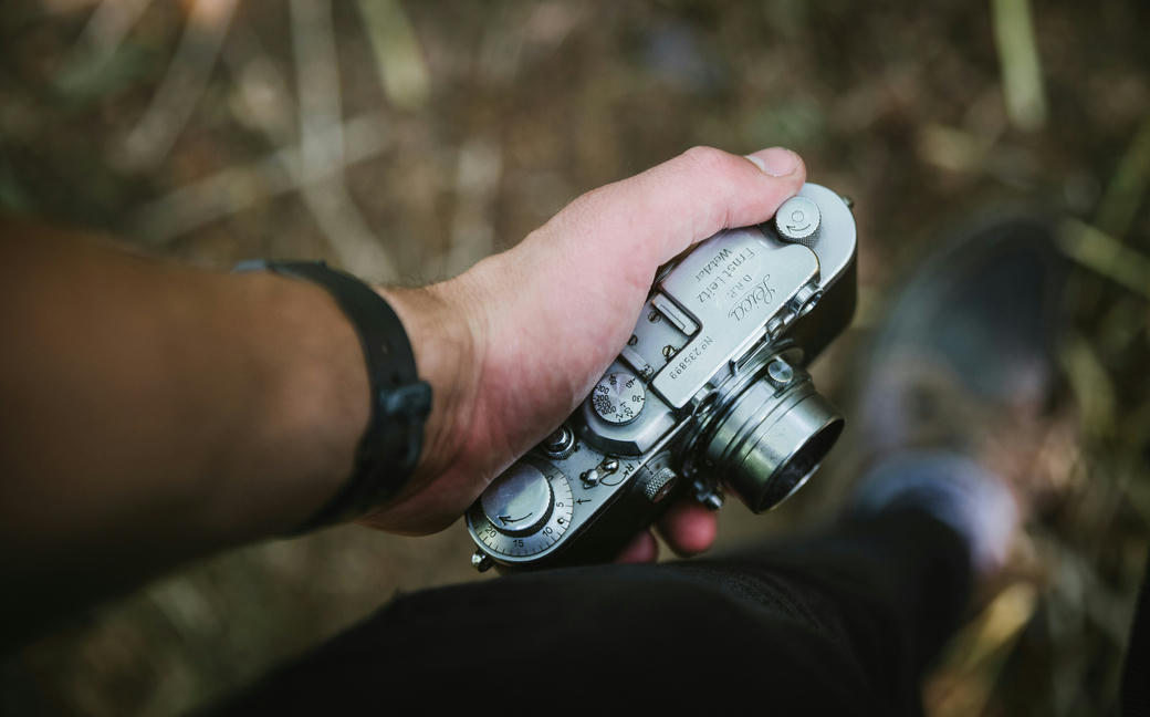 A man holds a vintage Leica camera